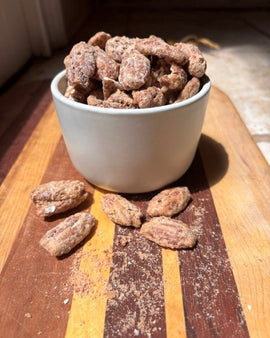 Bowl of Causey Foods Honey Cinnamon Roasted Pecans on rustic cutting board